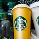Orange and white reusable cups featuring Starbucks logo